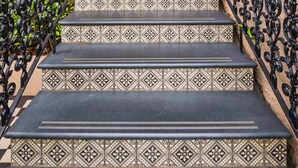A staircase with ornate black railings and patterned steps leading to a building entrance. - Perfect Located Studio Apartment (Sydney)