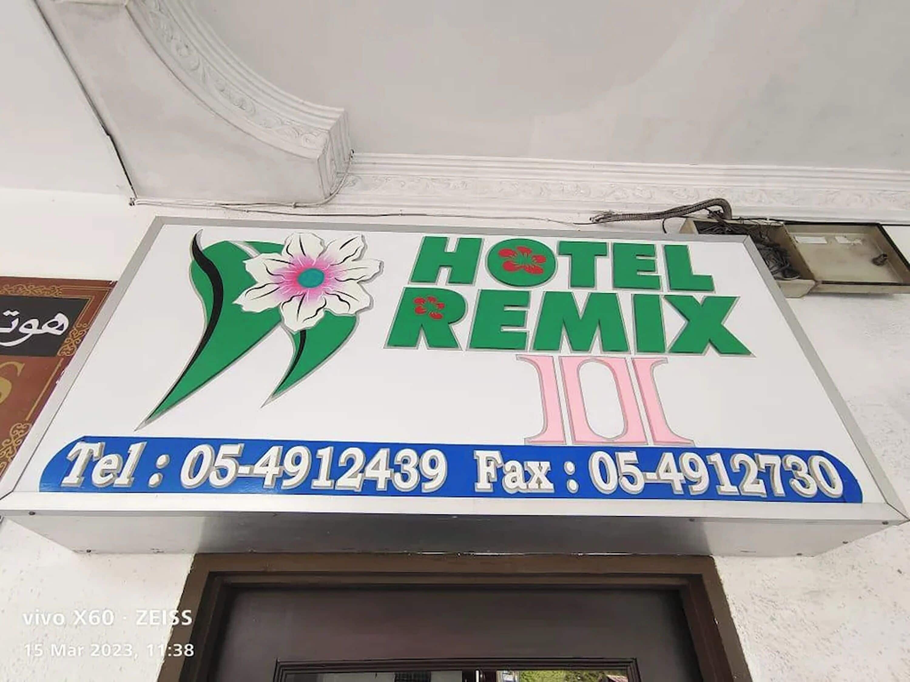 Señal de hotel con el nombre 'HOTEL REMIX' y números de contacto.