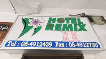 Señal de hotel con el nombre 'HOTEL REMIX' y números de contacto.