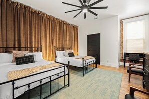 A bedroom with two beds, a ceiling fan, a wooden floor, a desk, and a chair. - Stable #1 ~Walkable, BBQ, Fire Pits, Mini Golf (Louisville)