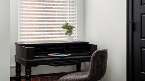 A corner room with a black piano bench, a chair, and a window with blinds. - Stable #1 ~Walkable, BBQ, Fire Pits, Mini Golf (Louisville)