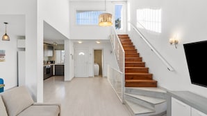 A spacious living area with a staircase, a kitchen, and a dining area. - Holiday Home 'París' with Sea Views, Wi-Fi and Air Conditioning (Benalmádena)