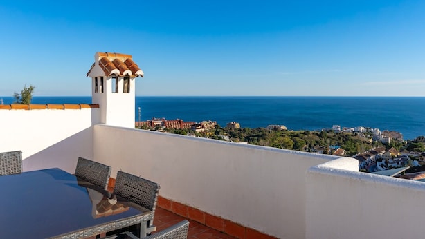 A terrace with a table and chairs, overlooking a coastal town and the sea. - Holiday Home 'París' with Sea Views, Wi-Fi and Air Conditioning (Benalmádena)