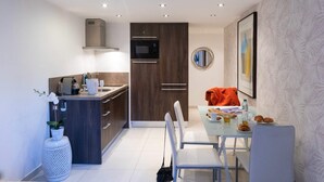 A modern kitchen with a dining area, featuring a microwave, stove, and a dining table with chairs. - Charming Riviera 2F - One Bedroom Apartment, Sleeps 4 (Antibes)