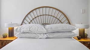 A bed with a wooden headboard, white bedding, two bedside tables with lamps, and a small plant on each table. - Windsor Cosy 2-bedroom Unit in Quiet Neighborhood (Brisbane)