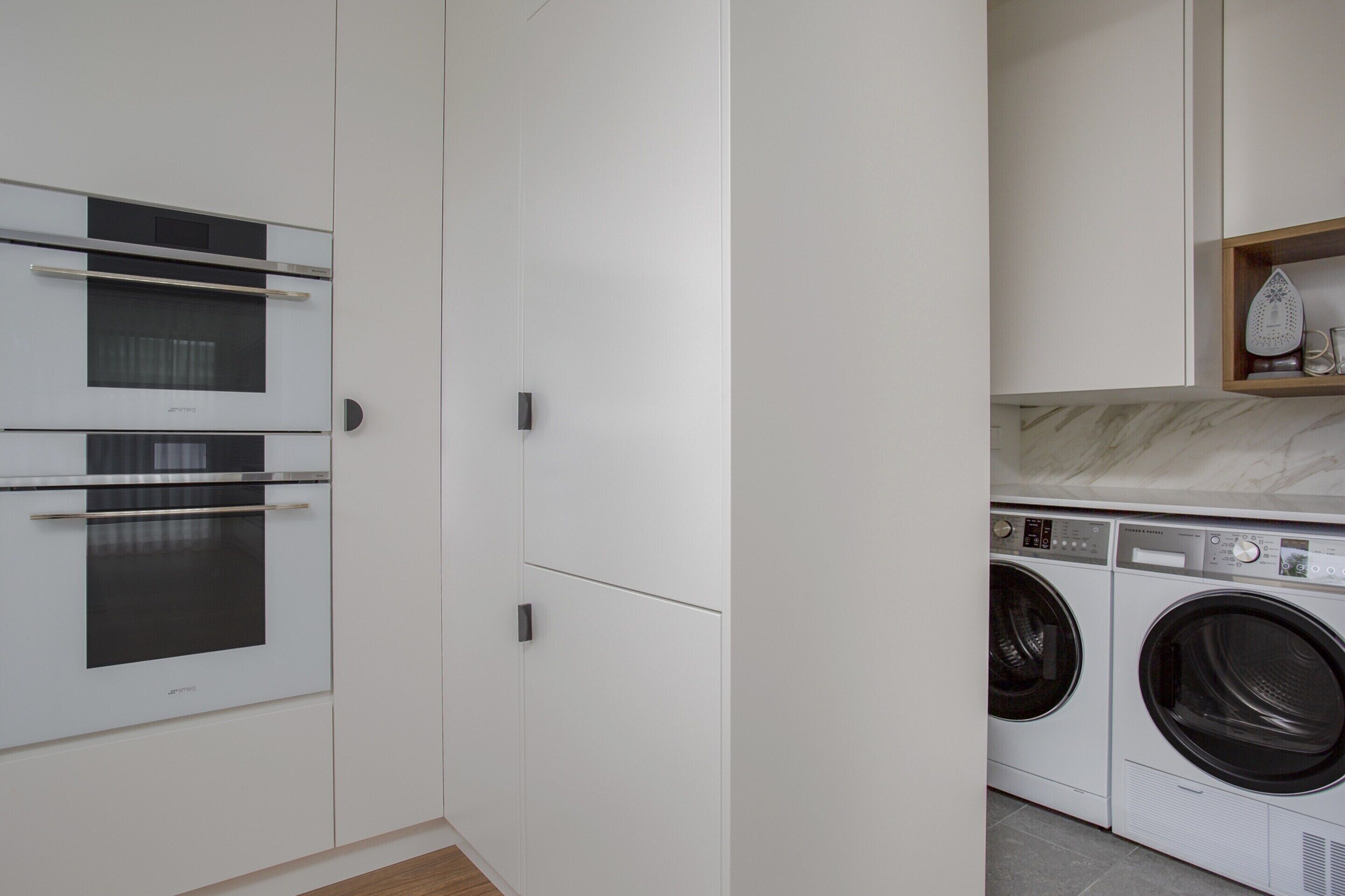 A modern kitchen with built-in appliances including an oven and a washing machine.