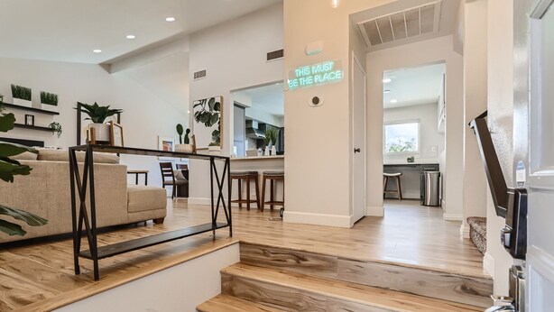 Ein modernes Interieur mit Treppe, einer Couch und Küchenzeile.
