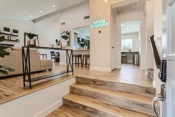 Ein modernes Interieur mit Treppe, einer Couch und Küchenzeile.