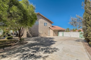 A two-story house with a tiled roof, a garage, and a fenced driveway. - Heated Pool with Cabana & GameRoom 15 Min to Strip (Las Vegas)