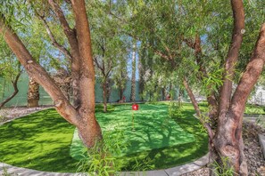 A circular green space with trees and a red flag.