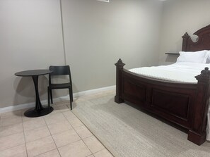 Un dormitorio con una cama, una mesita redonda y una silla.