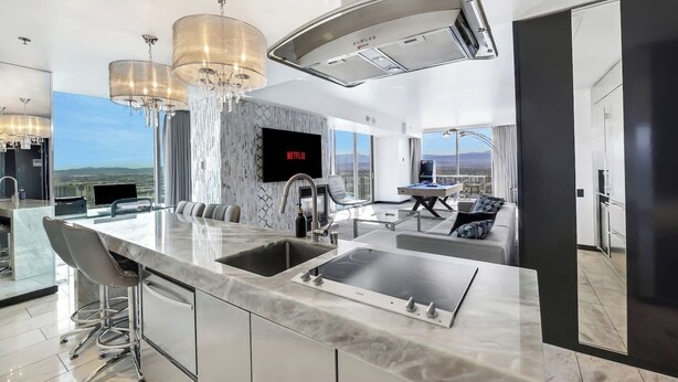 Una cucina moderna con una grande isola, una televisione a schermo piatto e un tavolo da biliardo.