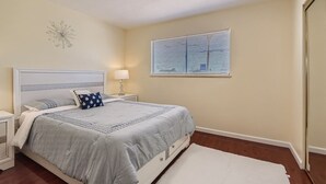 A bedroom with a bed, nightstands, a lamp, a window with blinds, and a ceiling light. - Cheerful Home with Game Room! 10 Min to Strip! (Las Vegas)