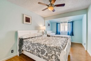 A bedroom with a bed, a ceiling fan, and a window with curtains. - Peaceful Family Getaway Centrally Located! (Las Vegas)