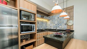 A modern kitchen with built-in appliances, wooden cabinets, and a tiled backsplash.