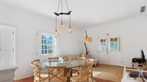 Un coin repas avec une table ronde, des chaises et un lustre.