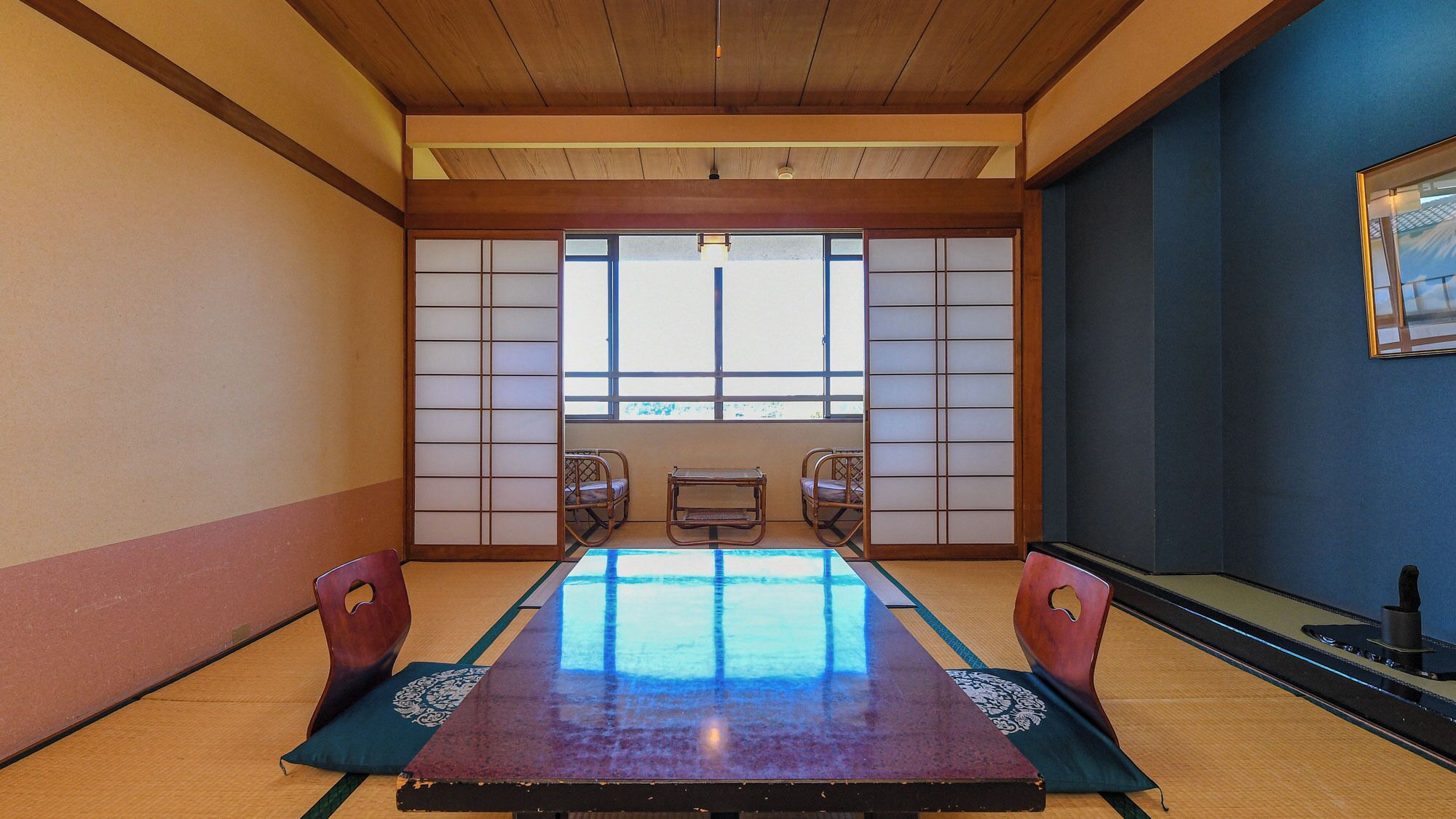 A traditional Japanese room with tatami flooring, a low table, and sliding doors.