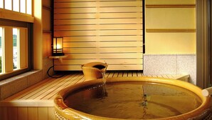 A traditional Japanese onsen with a wooden tub, a rope handle, and a small lantern. - Awara Onsen Mimatsu (Awara)