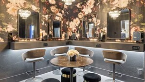 A modern bathroom with floral wallpaper, large mirrors, and a central round table with chairs. - Old Town's  Luxury Oasis - 16+ Guests, Designed for entertainment & relaxation. (Scottsdale)