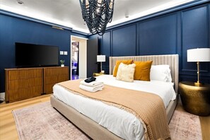 Ein Schlafzimmer mit einem großen Bett, einem Holzschrank und einem Flachbildfernseher.