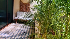 A room with a checkered floor, a sofa, and a large plant. - Casa libre  (Tulum)