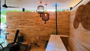 A modern interior with a long white table, wicker chairs, and hanging wicker lamps. - Casa libre  (Tulum)