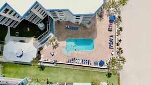 Ein Poolbereich auf dem Dach mit Pool, Liegestühlen und einer kleinen Terrasse.