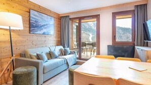 Una habitación moderna con sofá, mesa de comedor y televisor.