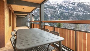 A balcony with a table and chairs, overlooking a mountainous landscape. - Wifi, 150m from resort center, swimming pool, sauna, hammam, balcony, parking, tv, ski locker, 53m² (Vaujany)