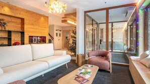 Una sala de estar moderna con sofá, sillón, mesa de centro y chimenea.