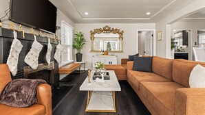A modern living room with a fireplace, a sofa, a coffee table, and a television.