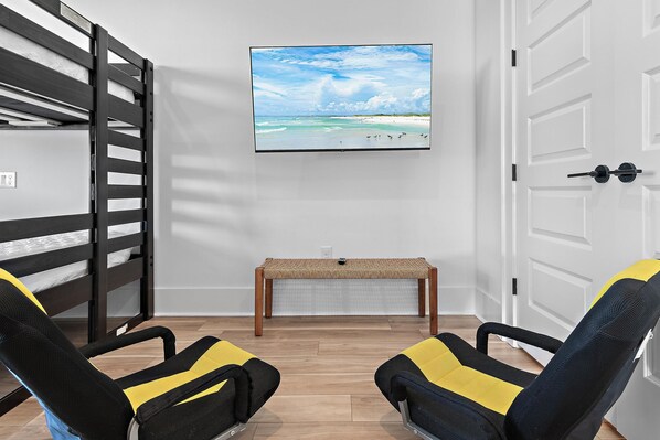 A room with a bunk bed, a bench, and two chairs with yellow and black cushions. - Scattered, Smothered, & Covered (Miramar Beach)