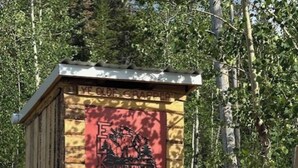 Un cobertizo de madera pequeño con una puerta roja, que dice 'Eagle Country USA'.