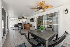 A dining area with a table, chairs, and a ceiling fan.