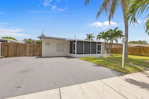 A single-story house with a garage, a covered porch, and a fenced yard.