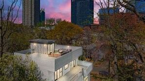 A modern two-story building with a flat roof, large windows, and a rooftop patio area. - Modern Retreat Near Atlantic Station (Atlanta)