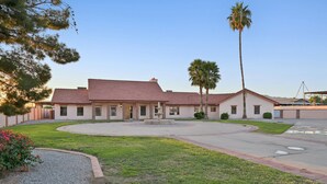 A two-story building with a central courtyard, palm trees, and a fountain.
