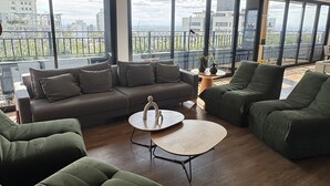 A spacious living room with a large window, a sofa, a coffee table, and a green armchair. - GO CARLOS GOMES (Porto Alegre)