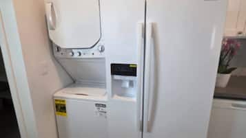 A compact kitchen with a built-in washer and dryer, a refrigerator, and a microwave.