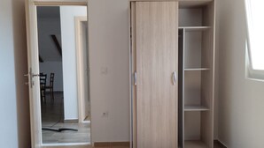 Una habitación con armario, una puerta que da a otra estancia y una ventana.
