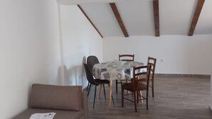 Un comedor con una mesa redonda, cuatro sillas y un sofá marrón.