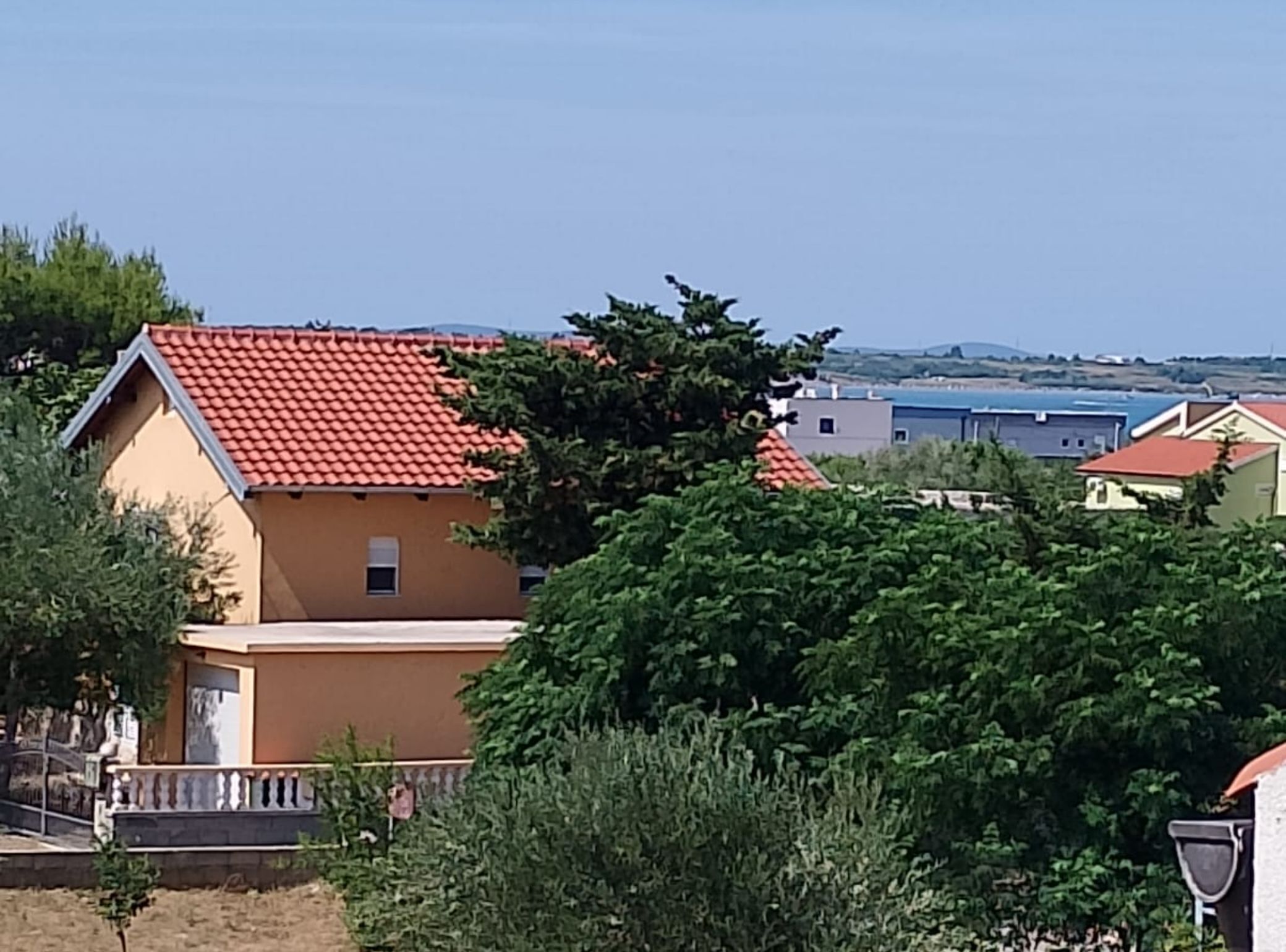 Ett bostadsområde med hus som har röda tegeltak och beige väggar.