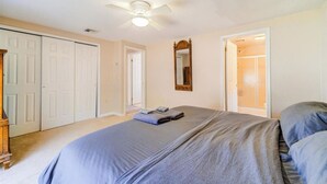 A bedroom with a bed, a ceiling fan, a mirror, and a closet. - Catskills Lakefront Getaway at Sackett Lake (Monticello)
