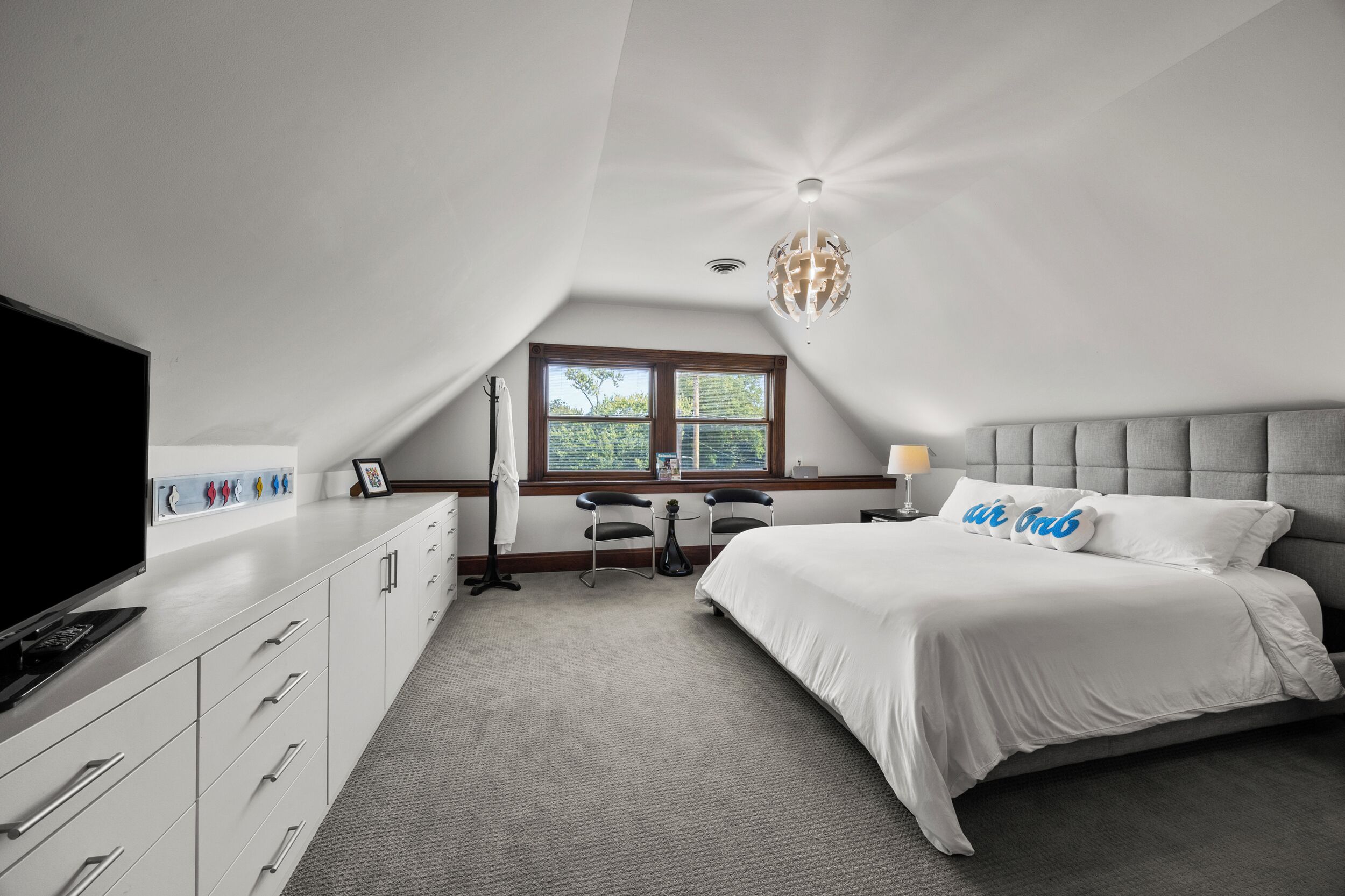 A bedroom with a bed, a desk, and a TV.