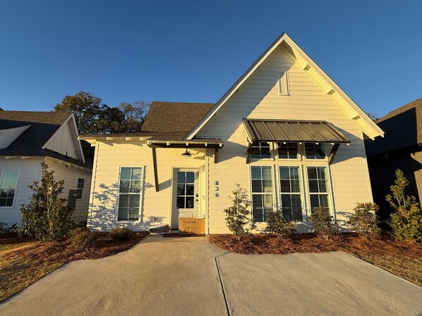 A two-story house with a gabled roof, a front porch, and a driveway. - 4BR Auburn–Opelika Escape | Sleeps 8 | Minutes to Tiger Town (Opelika)