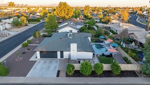 Ein Wohnhaus mit Garage, Schwimmbad und gepflegtem Rasen.