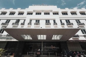 Un hôtel doté d’une façade moderne, de nombreux balcons et d’un espace d’entrée abrité.