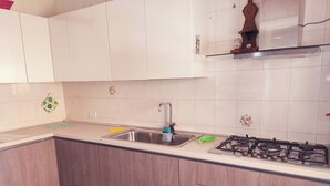 A kitchen with white cabinets, a stainless steel sink, a gas stove, and a patterned rug. - The Ideal Shelter for Families "Discover the heart of Mesagne (Mesagne)