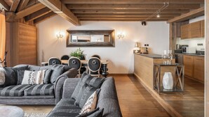 Ein gemütliches Wohnzimmer mit Sofa, Esstisch und Küchenbereich.