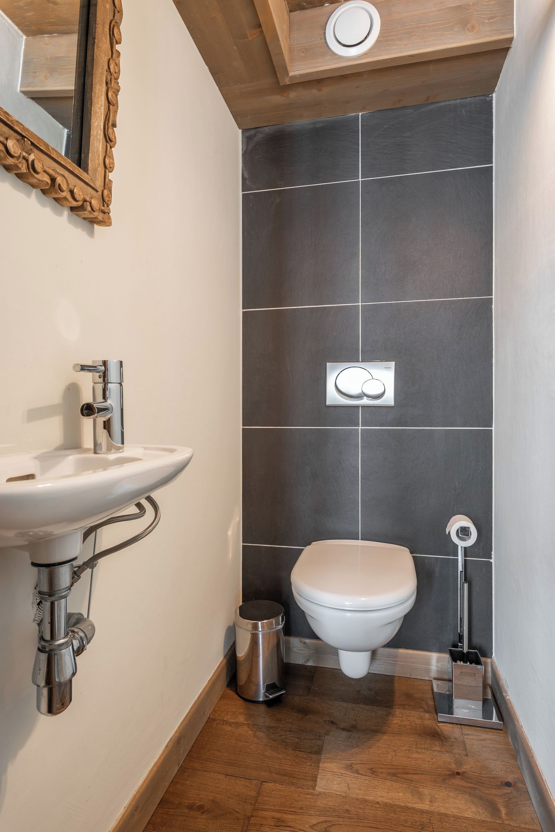 A modern bathroom with a white sink, a toilet, and a shower area.